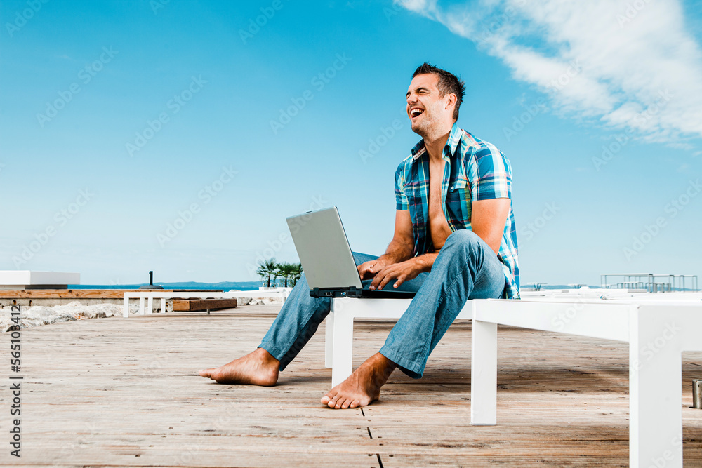 Man with the laptop on the modern beach resort 