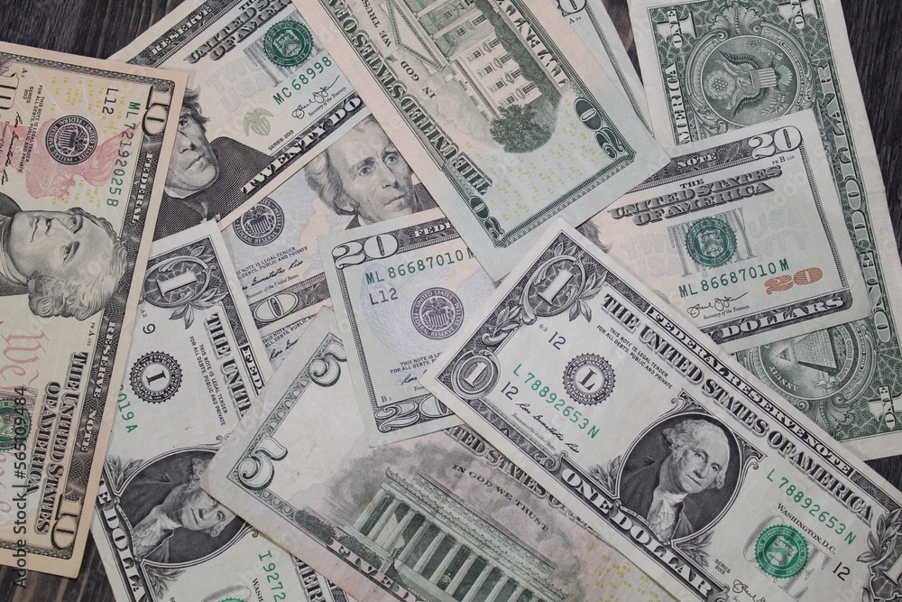 Multiple US dollar bills of different denominations scattered. Multiple US dollar bills of different denominations scattered.