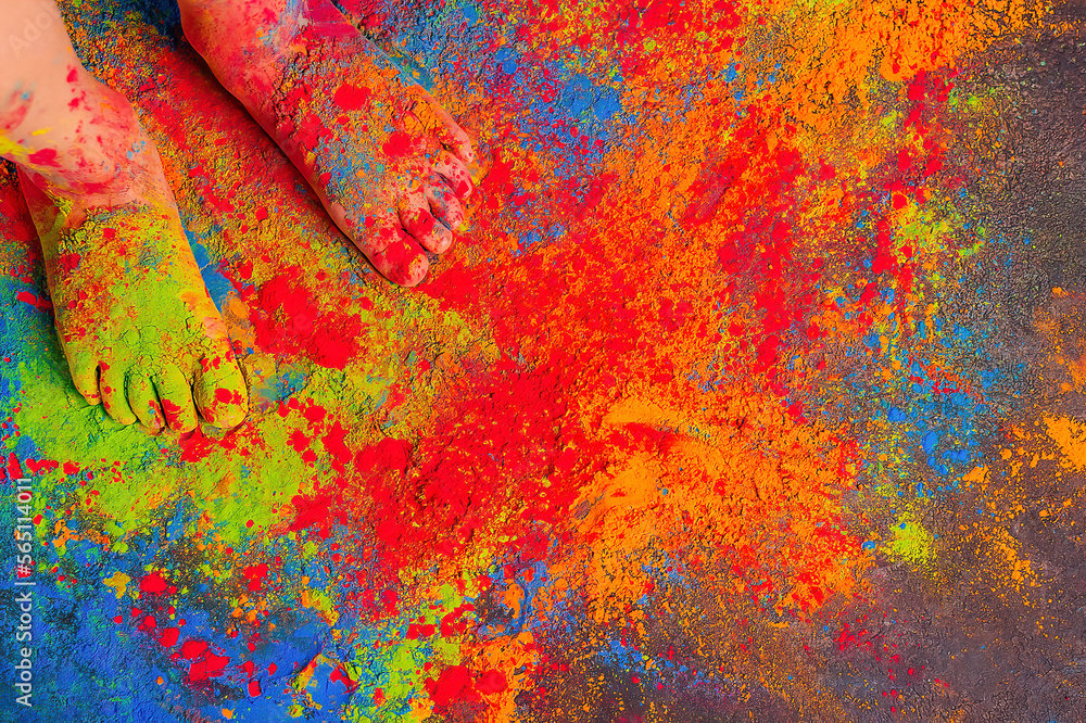 children's feet all sprinkled with multi-colored bright Holi colors, copy space. Indian festival of colors Holi.