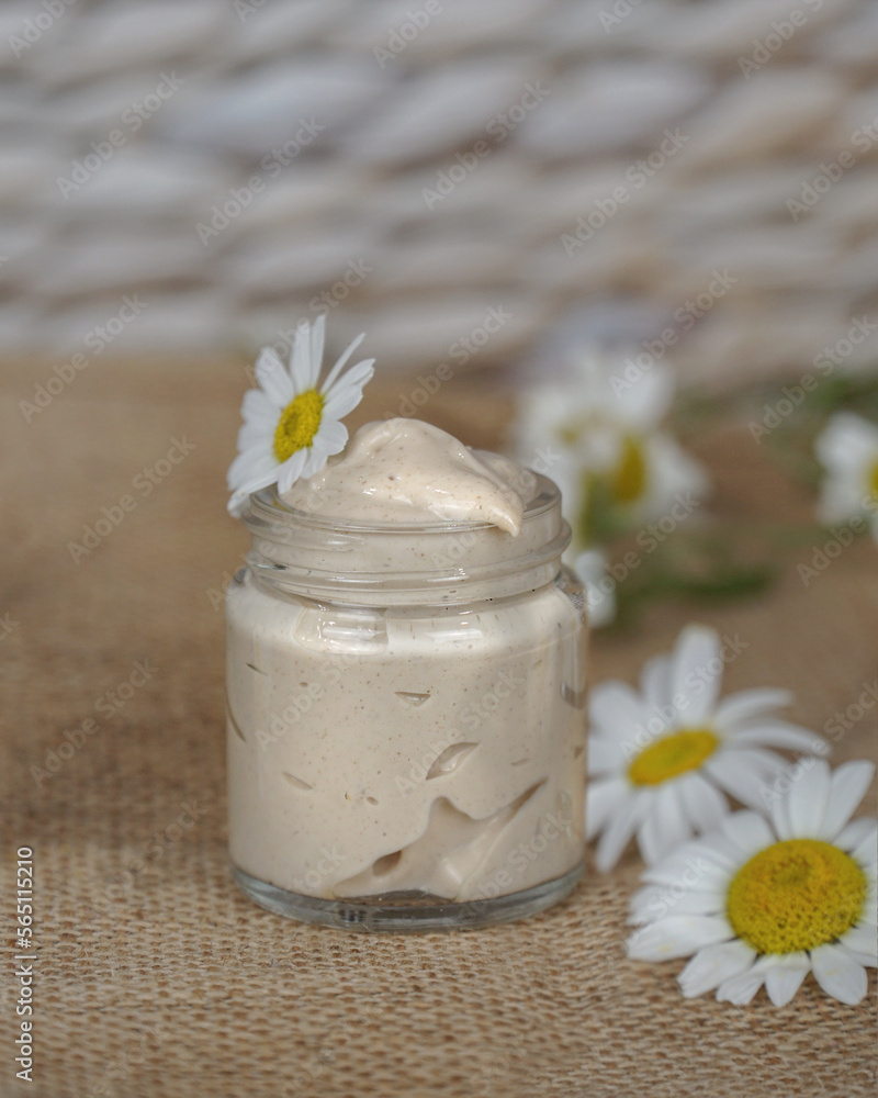 Cosmetic cream with camomile flower for a eye, face and body on beige and white background. Cosmetic cream with camomile flower for a eye, face and body on beige and white background.
