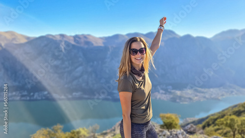 Woman with scenic view from mountain summit of Vrmac Sveti Ilija on Kotor bay in summer, Adriatic Mediterranean Sea, Montenegro, Balkans, Europe. Fjord winding along coastal towns. Hiking Dinaric Alps
