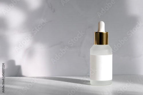 Matt glass dropper bottle mockup. Cosmetic bottle with blank label isolated on grey background with shadows and sunlight. 