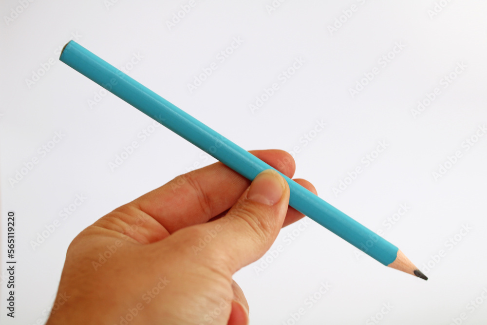 Hand holding triangular blue pencil isolated Hand holding triangular blue pencil isolated