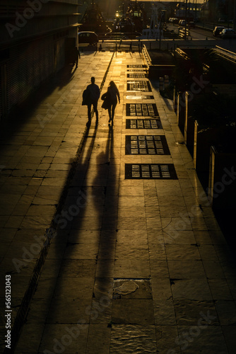 Sombras. Una pareja caminado a última hora de la tarde con el sol a sus espaldas, proyectando una gran sombra sobre el suelo.
