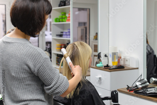 hairdresser doing stylish styling to woman in salon