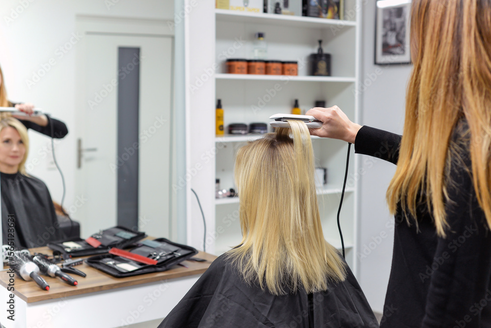hairdresser doing stylish styling to woman in salon hairdresser doing stylish styling to woman in salon