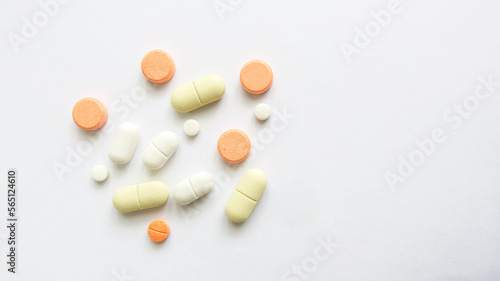 Assorted scattered pharmaceutical medicine pills and tablets in various colour and size isolated in white background, copy space for text or advertising
