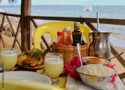 A delicious fish in shrimp sauce, accompanied by a healthy juice from local fruits, on a paradisiacal beach on the coast of Alagoas, northeastern Brazil photo