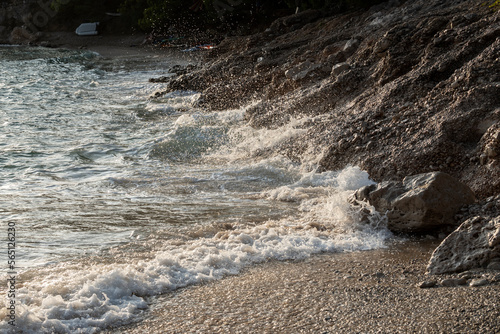 Fototapeta Naklejka Na Ścianę i Meble -  Waves splashing sand beach of Brac island, Croatia during beautiful summer sunset creating white foam