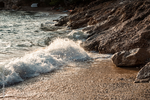 Fototapeta Naklejka Na Ścianę i Meble -  Waves splashing sand beach of Brac island, Croatia during beautiful summer sunset creating white foam