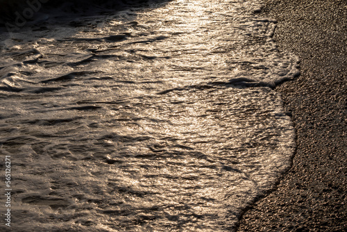 Fototapeta Naklejka Na Ścianę i Meble -  Waves splashing sand beach of Brac island, Croatia during beautiful summer sunset creating white foam