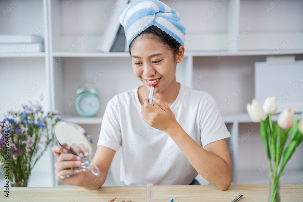Attractive asian woman doing make up in living room at morning.. Attractive asian woman doing make up in living room at morning..