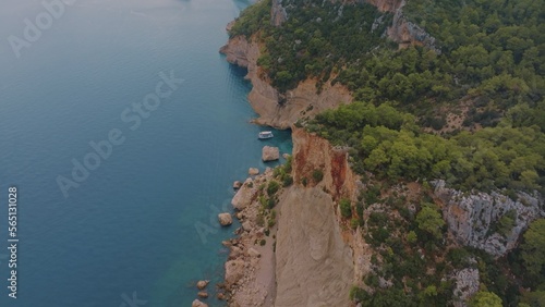 Beautiful seascape. Top view of a rocky shore covered with green trees. Blue water. Aerial view. Photography photo