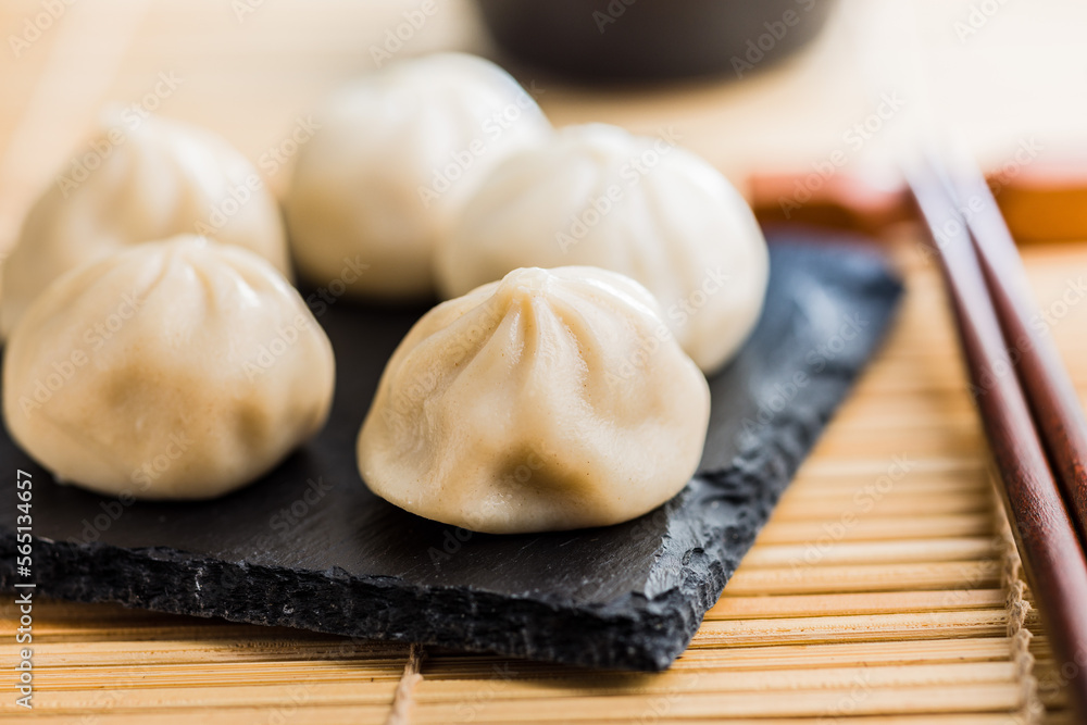 Xiaolongbao, traditional steamed dumplings. Xiao Long Bao buns on cutting board. Xiaolongbao, traditional steamed dumplings. Xiao Long Bao buns on cutting board.