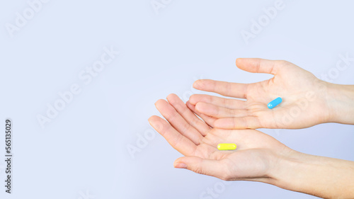Blue and yellow capsules lies in human hand isolated on white background Medical Treatment Pharmacy Health