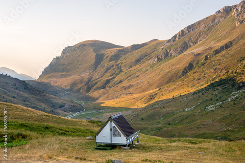 Quiet place in the mountains with a small wooden bungalow house in a campsite for peaceful and relaxing vacations in the summer. Alps, mountains background. Quiet lifestyle. Piedmont, Mondovì, Italy