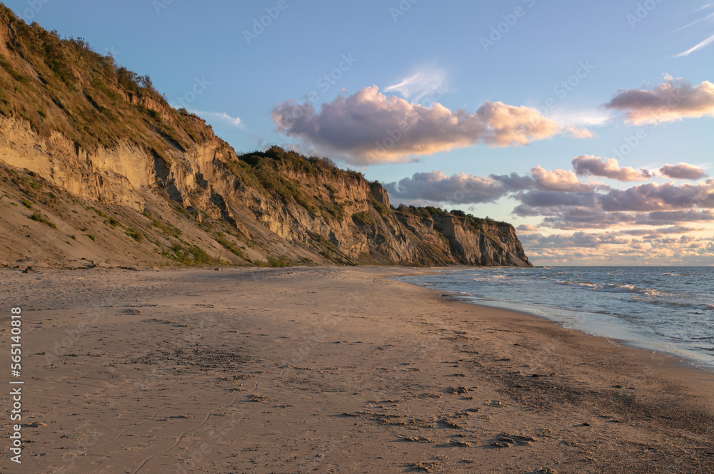 Landscape of the Baltic Sea coast in northern Europe. High steep cliff, sandy beach. Warm autumn day, yellow colors of golden autumn. Landscape of the Baltic Sea coast in northern Europe. High steep cliff, sandy beach. Warm autumn day, yellow colors of golden autumn.