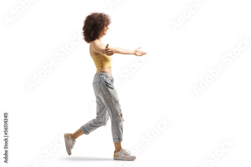 Full length profile shot of a young woman with afro hairstyle walking to hug somebody