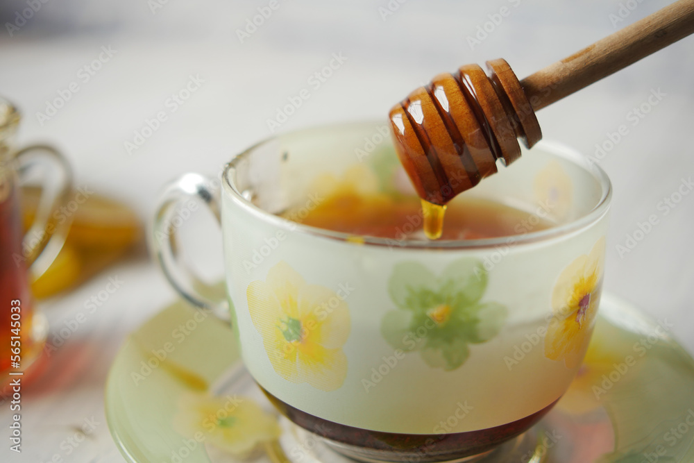 pouring honey in green tea on table pouring honey in green tea on table