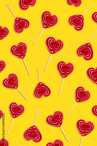 Red heart lollipops pattern on yellow background