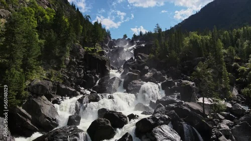 Aerial view of the cascading Uchar waterfall, flowing over rocks and forests photo