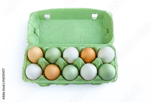 Eggs with different shell colors in a cardboard package on a white background photo