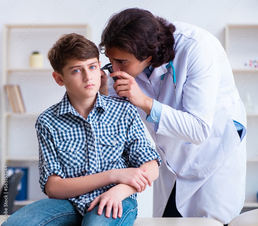 Obraz premium Male otolaryngologist examining boy's ear