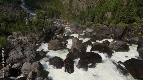 Aerial view of the cascading Uchar waterfall, flowing over rocks and forests photo