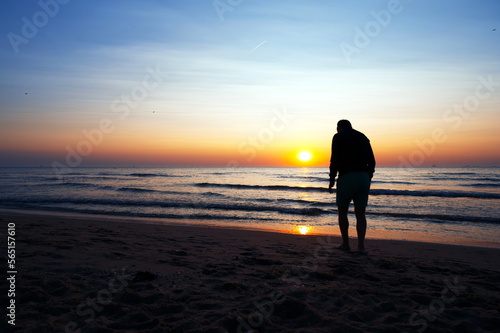 man walking on the beach at sunset