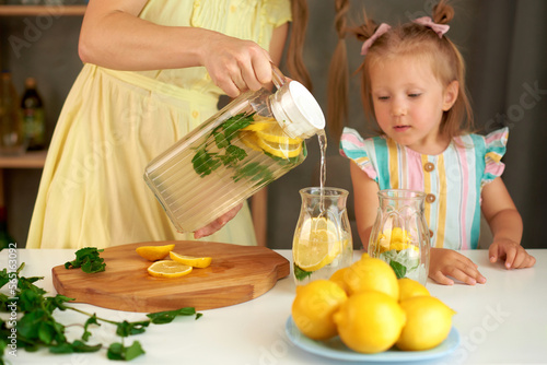 Obraz na plátně mother pours lemonade for daughter