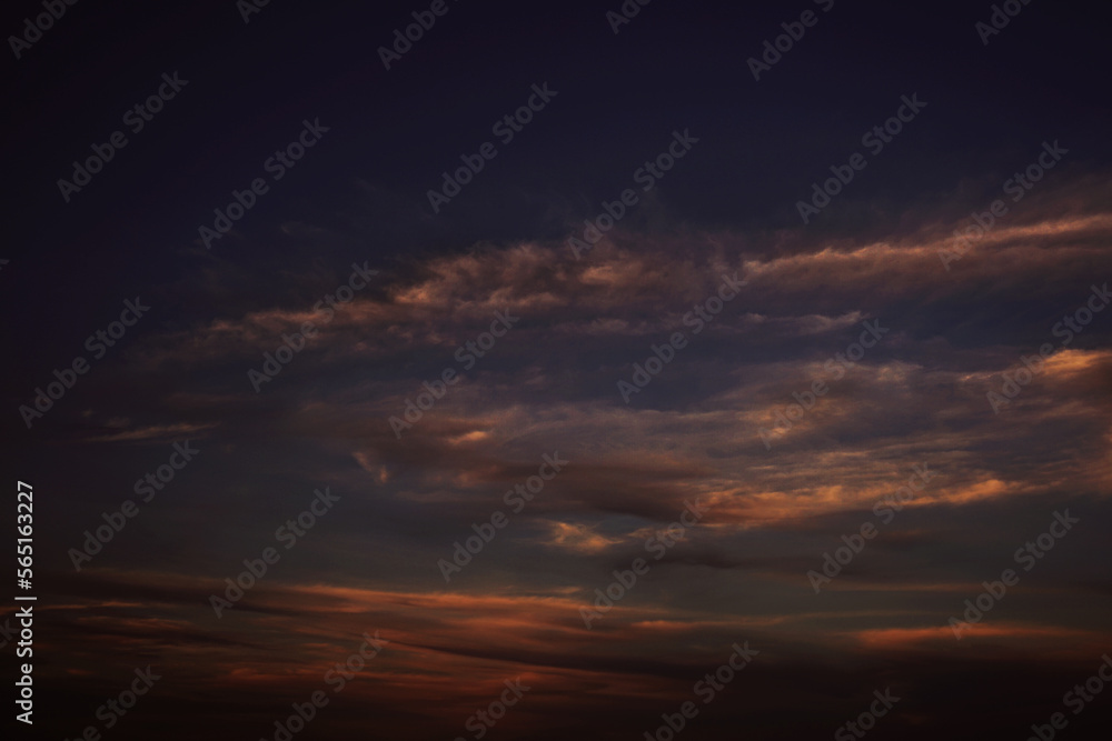Orange red sunset. Dark violet blue evening sky with clouds. Background for design. Dramatic skies.