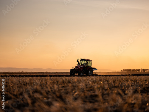 Tractor plowing and preparing stubble field for crop cultivation