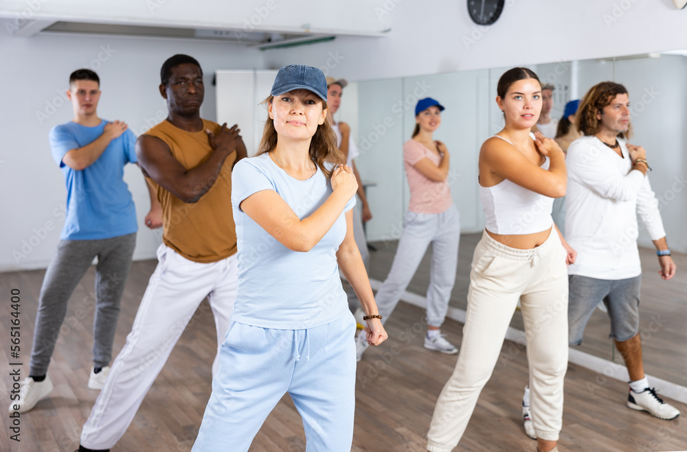 Fototapeta premium Group of positive dancers repeat dance in dance hall