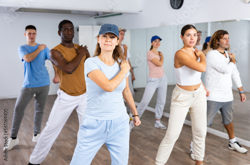 Group of positive dancers repeat dance in dance hall