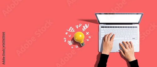 Person using a laptop computer and a light bulb