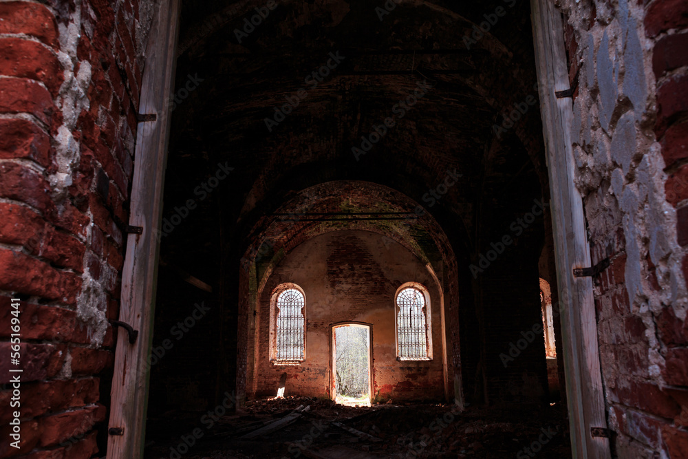 Fototapeta premium An old ruined temple, a red brick church, inside, windows with iron bars. Architecture, faith.