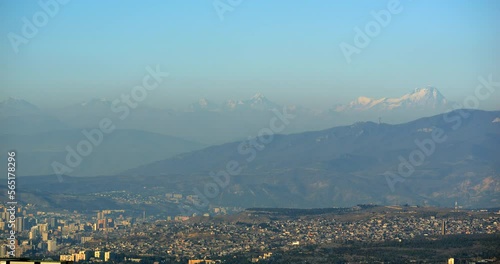 View of the city of Tbilisi and Rustavi with mount Kazbek in the morning haze against the blue sky on the backgroundi. The top of Mount Kazbek is one of the eight five-thousanders of the Caucasus photo