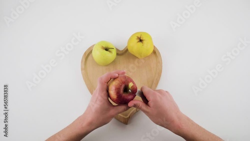 Hand peel pare off apple fruit with knife on white background. Guy or man peeling off red apple fruit on white background. Healthy diet food raw vegan based. 4k hd mandarin high quality video.   