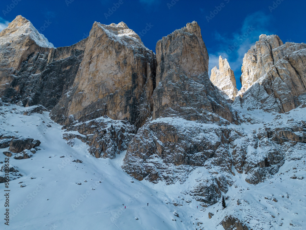 Tiny hikers on a winter trail towards Vajolet Refuge from Vigo di Fassa, Dolomites, Italy