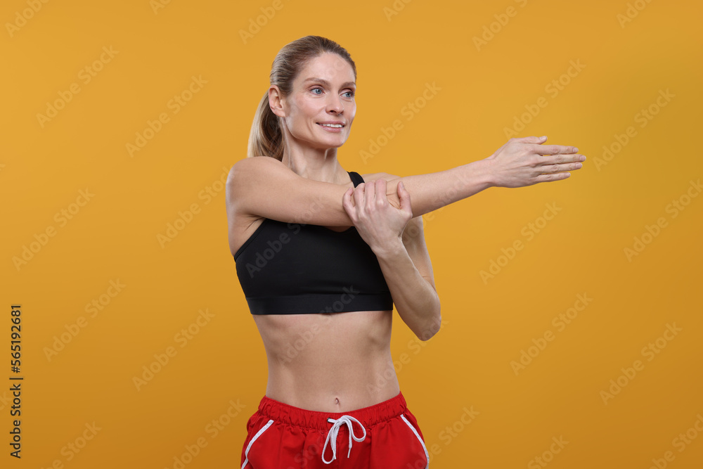 Portrait of sportswoman stretching on yellow background, space for text Portrait of sportswoman stretching on yellow background, space for text