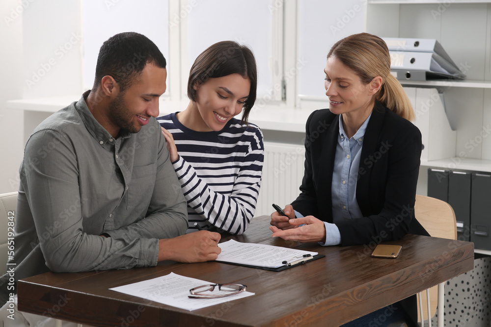 Professional notary helping couple with paperwork in office Professional notary helping couple with paperwork in office