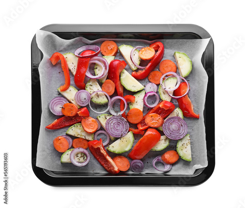 Baking pan with parchment paper and raw vegetables isolated on white, top view