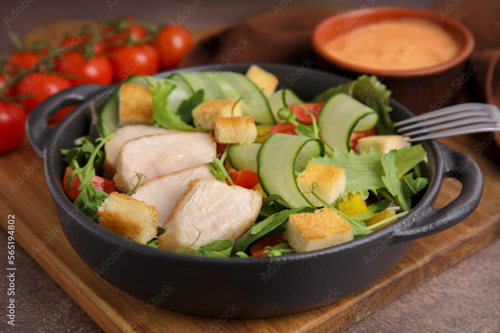 Delicious salad with croutons, chicken and vegetables served on grey table, closeup Delicious salad with croutons, chicken and vegetables served on grey table, closeup