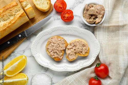 Tasty sandwiches with cod liver on white marble table  flat lay