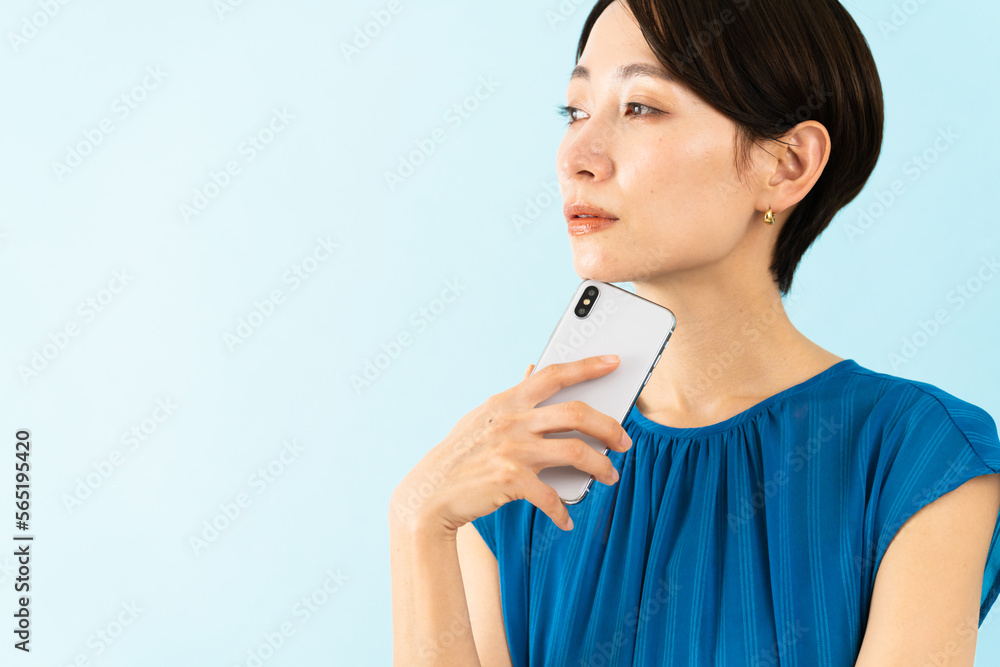 スマートフォンを使うワンピースを着た若い女性 スマートフォンを使うワンピースを着た若い女性