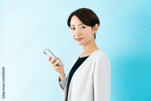 スマートフォンを使う若い女性 ビジネスイメージ