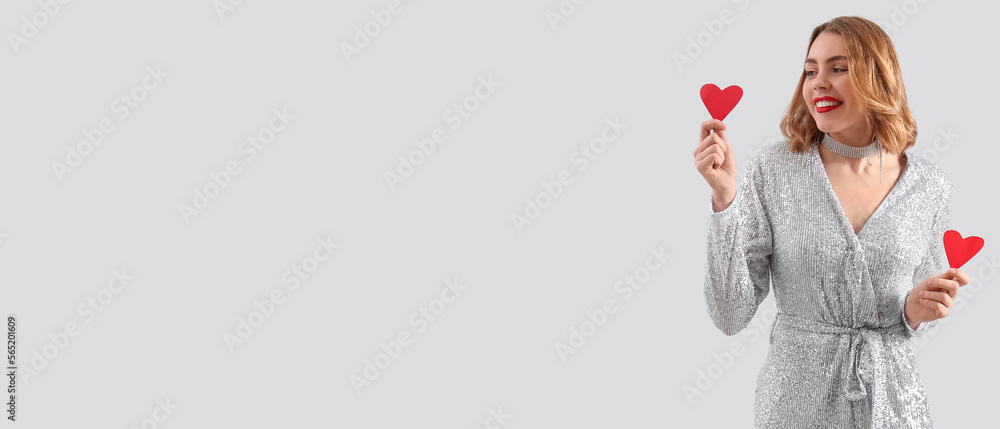 Beautiful young woman with small red hearts on light background with space for text Beautiful young woman with small red hearts on light background with space for text