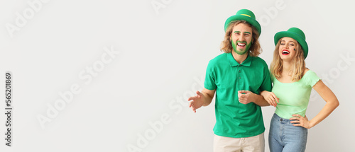 Young couple on light background with space for text. St. Patrick's Day celebration