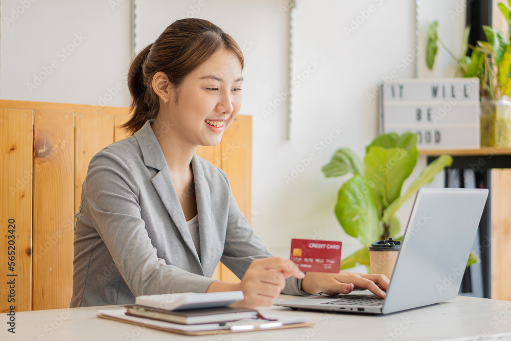 Asian woman holding credit card and typing keyboard on laptop online shopping Girl doing online checkout using laptop for shopping at home online shopping concept Asian woman holding credit card and typing keyboard on laptop online shopping Girl doing online checkout using laptop for shopping at home online shopping concept