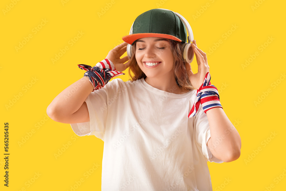 Female hip-hop dancer in headphones on yellow background Female hip-hop dancer in headphones on yellow background